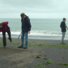 Fabrice and Joel playing a game in the sand, Nico and Nicolas chatting behind