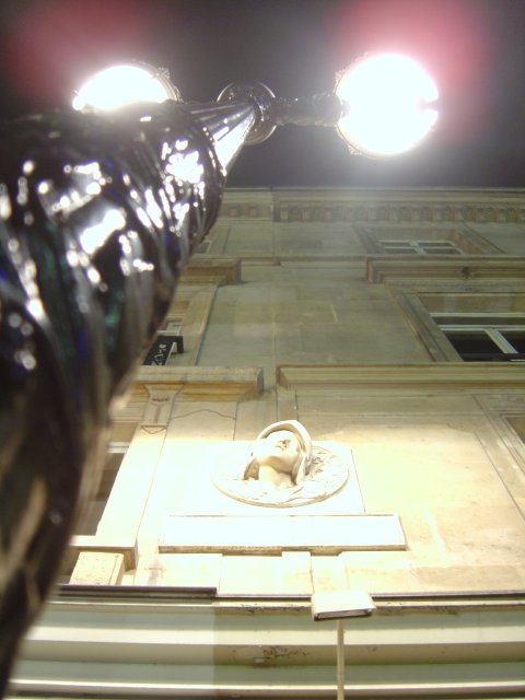Street lights and sculpture on a wall
