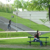 Man on stilts, couple on a bench