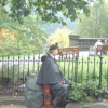 Bagpiper sitting on his bagpipe case by Princes Street Gardens