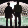 Robin and Mason standing in front of a brightly lit fountain, Monaco