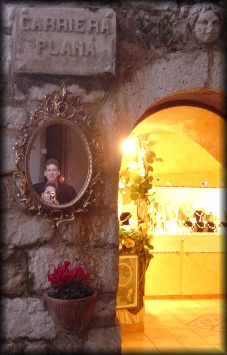 ericP's and my reflection in an oval mirror hung on the brick wall next to a shop