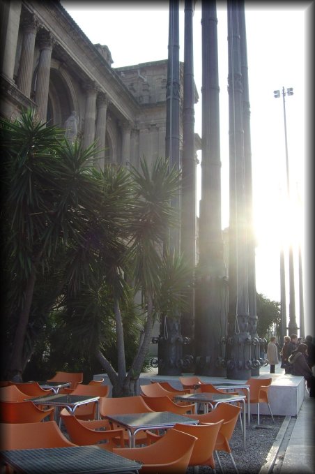 Orange chairs and aluminium table on a terrace next to the entrance of the MNAC.