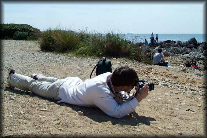 Guillaume lying flat on his belly to shoot a picture