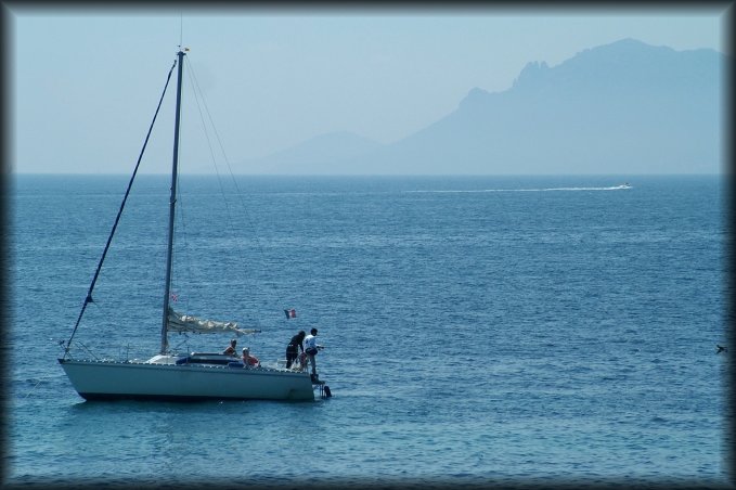 A sailing boat, the sea, and haze in the background hiding a little l'Esterel