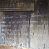 A note to visitors written with chalk, informing this is not an abandoned village.