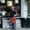 Bagpiper piping in front of Deacon Brodie's on the Royal Mile.