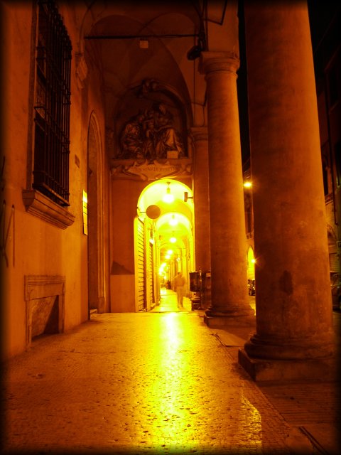 Arcades at night, man coming forward.