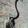 An iron happy duck on a brick wall. (Really I have no idea what it is).