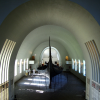 People look small as they walk by the Oseberg Ship at the Viking Ship Museum.  <em>The Oseberg Ship was found in a large burial mound at the Slagen farm in Vestfold and excavated in 1904. The ship was built in around 815-820 A.D. and had been used as a sailing vessel for many years before it was put to use as a burial ship for a prominent woman who died in 834. The ship, built of oak, was 22 meters long and 5 meters wide. The 12 strakes were secured with iron nails. The ship was designed for both rowing and sailing. With a square sail of about 90 sq. m., it could reach speeds of over 10 knots. The top strake had 15 oar holes.</em>  <em>The skeletons of two women were found in the grave. One, aged 60-70, suffered badly from arthritis and other maladies; the second was aged 25-30. It is not clear which one was the most important in life, or whether one was sacrificed to accompany the other in death. Although the high-ranking woman's identity is unknown, it has been suggested that it is the burial of Queen Asa of the Ynglinge clan, mother of Halfdan the Black and grandmother of Harald Fairhair. This theory is now generally dispelled, and it is now thought that she may have been a priestess.</em>