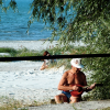 This man was absorbed in his music, his back to the sea, away from the people and near the dirt path. He was playing a mandolin, a happy smile on his face.