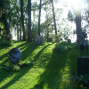 A green mound in the Helsinki cemetery and the sun casting long shadows.